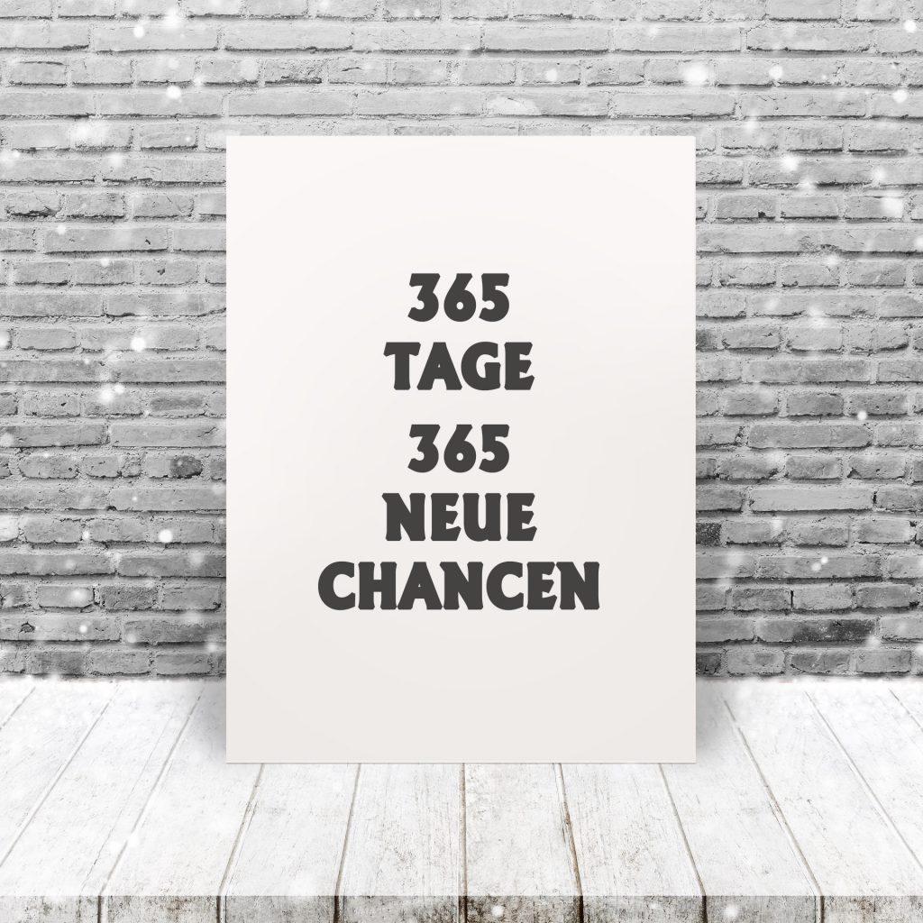 Inspiration Quote "365 new days, 365 new chances" on paper at wooden table top and old brick wall background with snowfall.